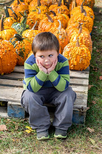 Overwhelmed little boy at a pumpkin patch has too many choices