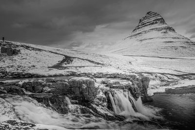 Scenic view of waterfall against sky during winter