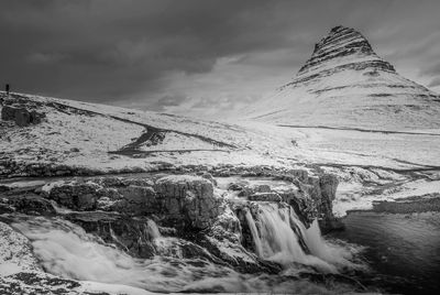 Scenic view of waterfall against sky during winter