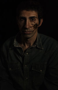 Portrait of young man against black background