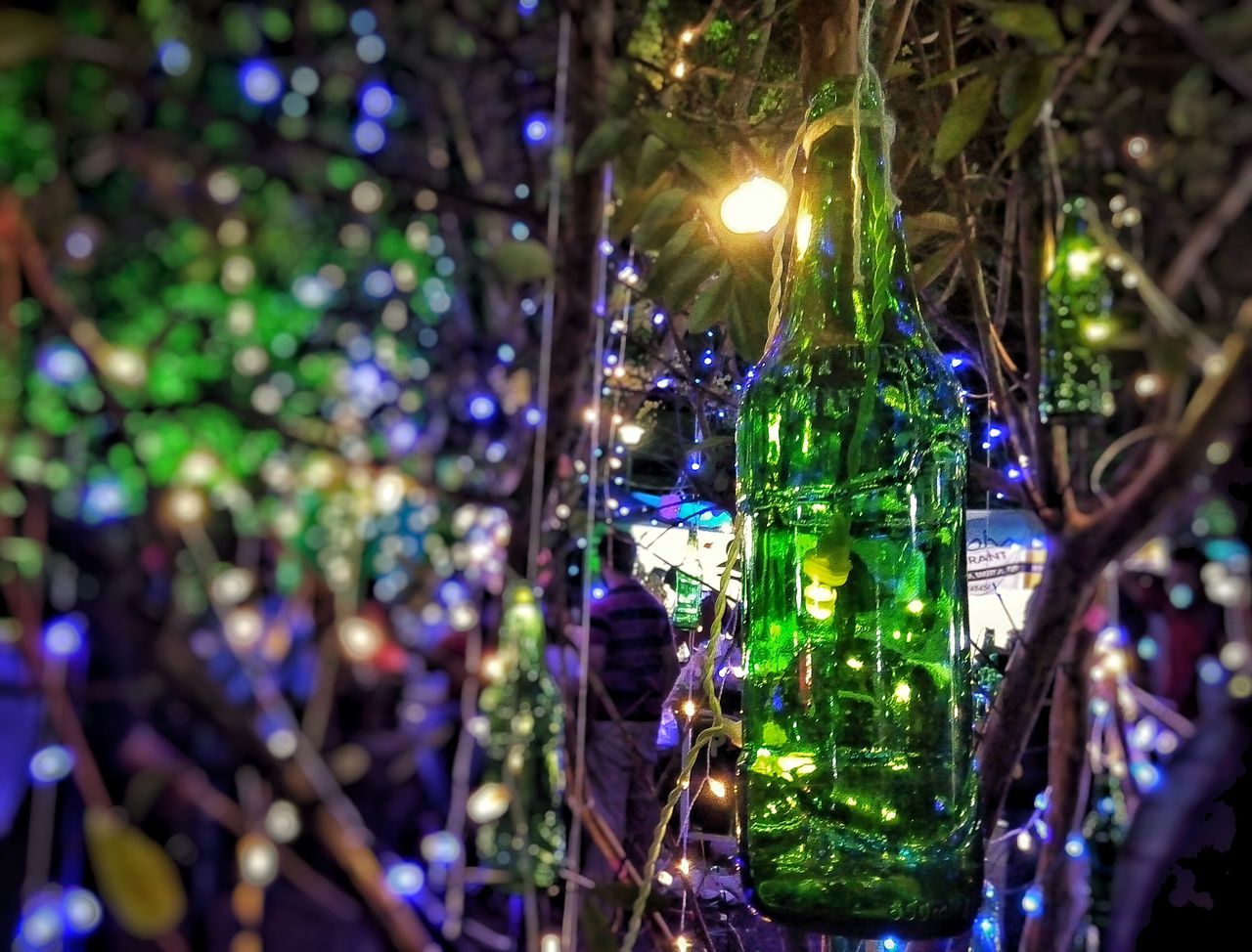 illuminated, focus on foreground, close-up, decoration, lighting equipment, green color, hanging, lens flare, reflection, christmas decoration, celebration, night, selective focus, glass - material, transparent, water, outdoors, no people, shiny, christmas