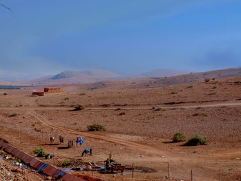 People on arid landscape against sky