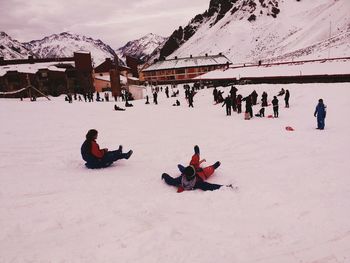 People enjoying on snow covered mountain