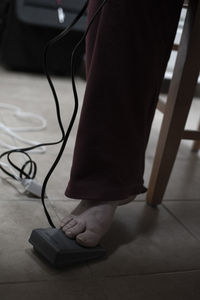 Low section of woman standing on equipment at home