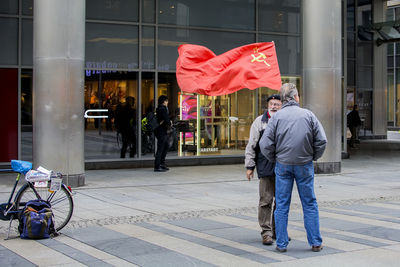 Man and bicycle on street against building