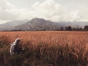 Person on agricultural field against sky