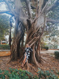 Midsection of woman amidst trees in forest