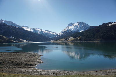 Scenic view of lake and snowcapped mountains against sky