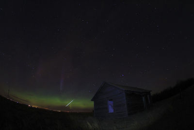 House on landscape against sky at night