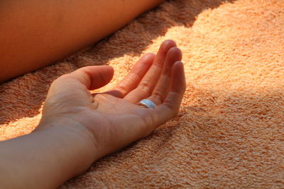 Cropped hand of woman on bed