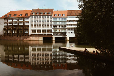 Reflection of building in lake against sky