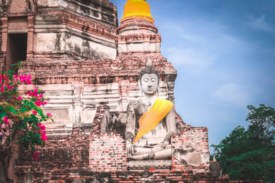 Low angle view of statues on building against sky