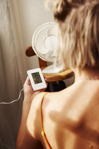 Woman holding thermostat at home