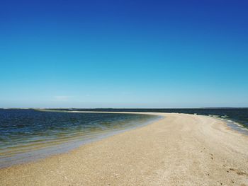 Scenic view of beach against clear blue sky