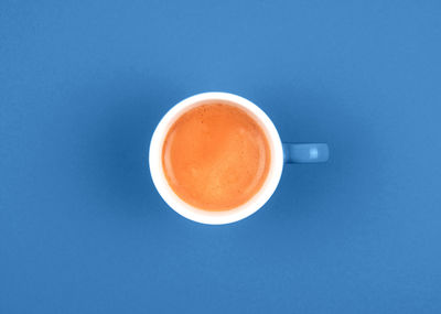 Directly above shot of coffee on table against blue background