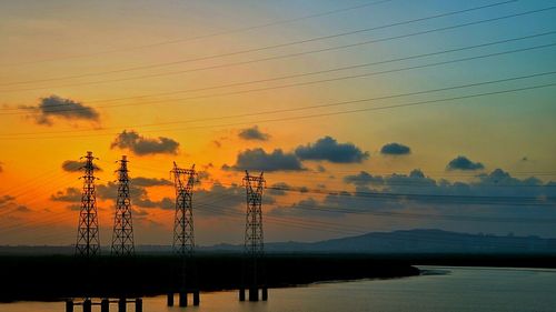 Silhouette electricity pylon against sky during sunset