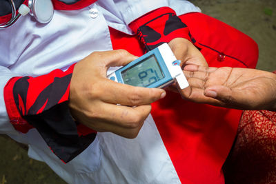 Midsection of man holding mobile phone