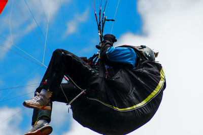 Low angle view of person paragliding against sky