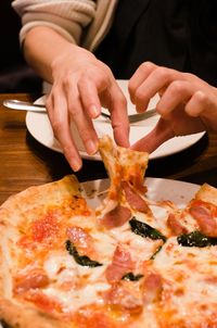 Close-up of hand holding pizza