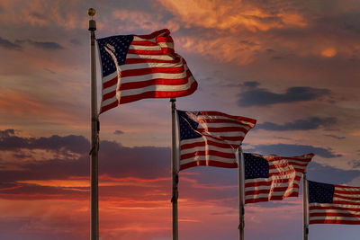 Low angle view of flags flag against sky during sunset