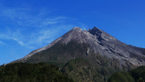 Low angle view of mountain against blue sky