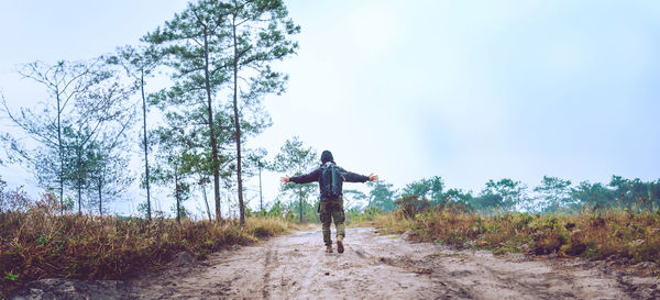 Rear view of man walking on road