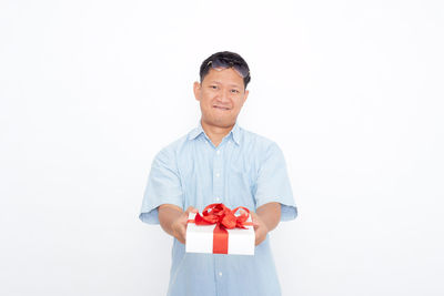 Portrait of man standing against white background