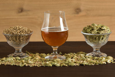 Glass of beer, hops, and malt on a table