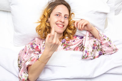 Portrait of smiling young woman sitting on bed