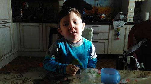 Portrait of cute baby boy sitting at home