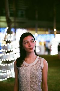 Young woman standing in city at night