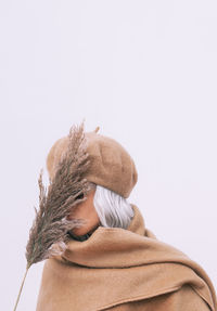 Woman in warm clothing against white background