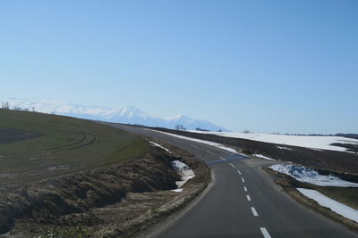 Road passing through landscape against clear sky