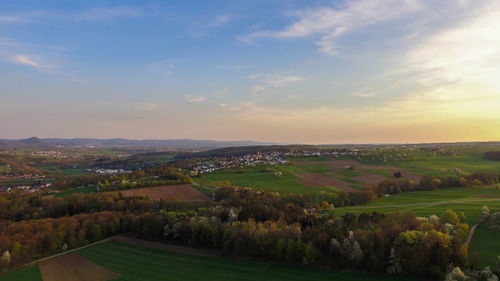 Scenic view of agricultural landscape against sky during sunset