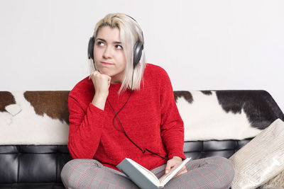 Young woman sitting on sofa at home