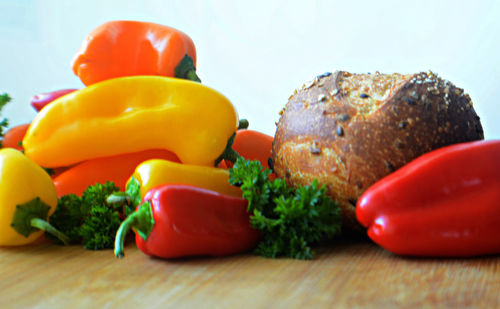 Close-up of fresh bread with multi colored bell peppers on table