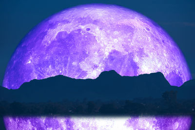 Scenic view of illuminated mountains against sky at night