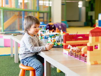 Cute boy playing with toy at kindergarten