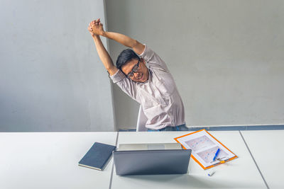 Man working on table against wall