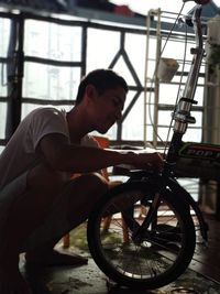 Side view of young man sitting on bicycle