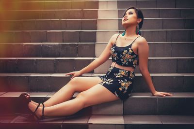 Full length of young woman sitting on steps