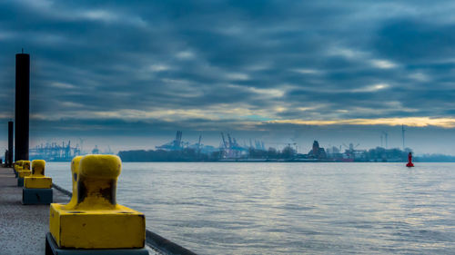 Distant of view of dock against cloudy sky