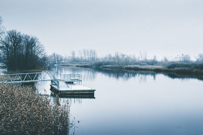 Scenic view of lake against clear sky during winter