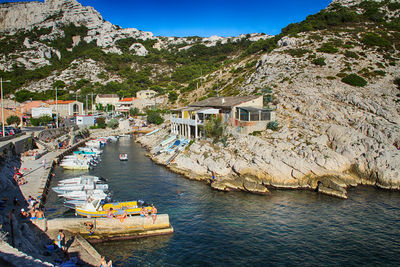 Boats moored in lake against rocky landscape