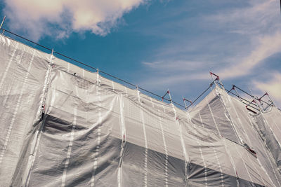 Building under construction with protective net for safety and prevention dust and accidents.