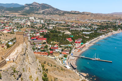 Aerial view of town by sea against sky