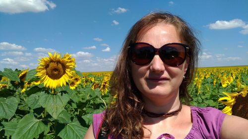 Close-up portrait of smiling young woman against blue sky