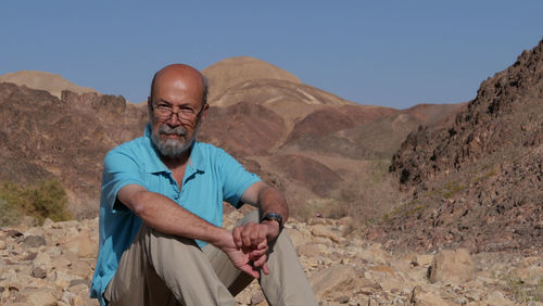 Portrait of senior man sitting in the desert 
