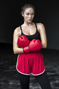 Female boxer with arms crossed standing at basement