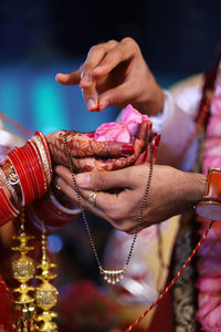 Midsection of couple performing traditional ritual